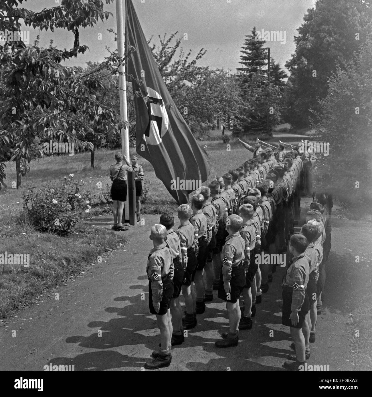 Morgendlicher Fahnenappell im Jungen Landjahr Lager in Bevensen in der Lüneburger Heide, Deutschland 1930er Jahre. Matutinal flag muster at the Hitler youth camp at Bevensen, Germany 1930s. Stock Photo