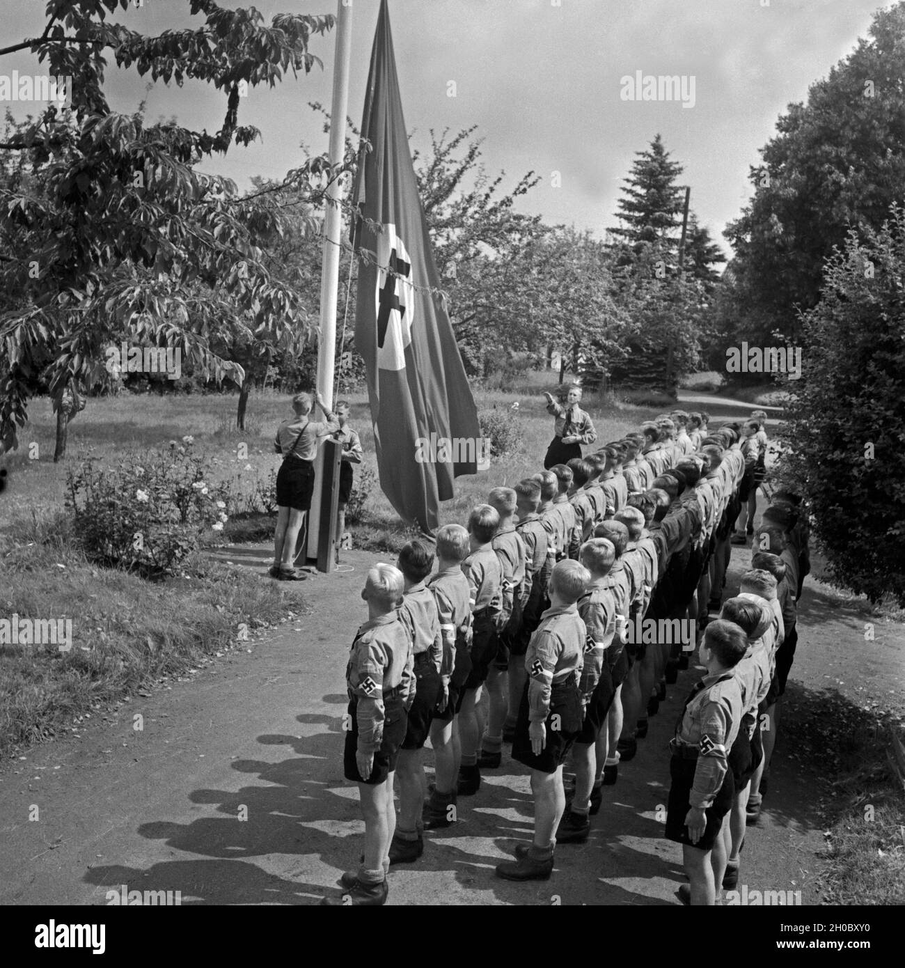 Morgendlicher Fahnenappell im Jungen Landjahr Lager in Bevensen in der Lüneburger Heide, Deutschland 1930er Jahre. Matutinal flag muster at the Hitler youth camp at Bevensen, Germany 1930s. Stock Photo