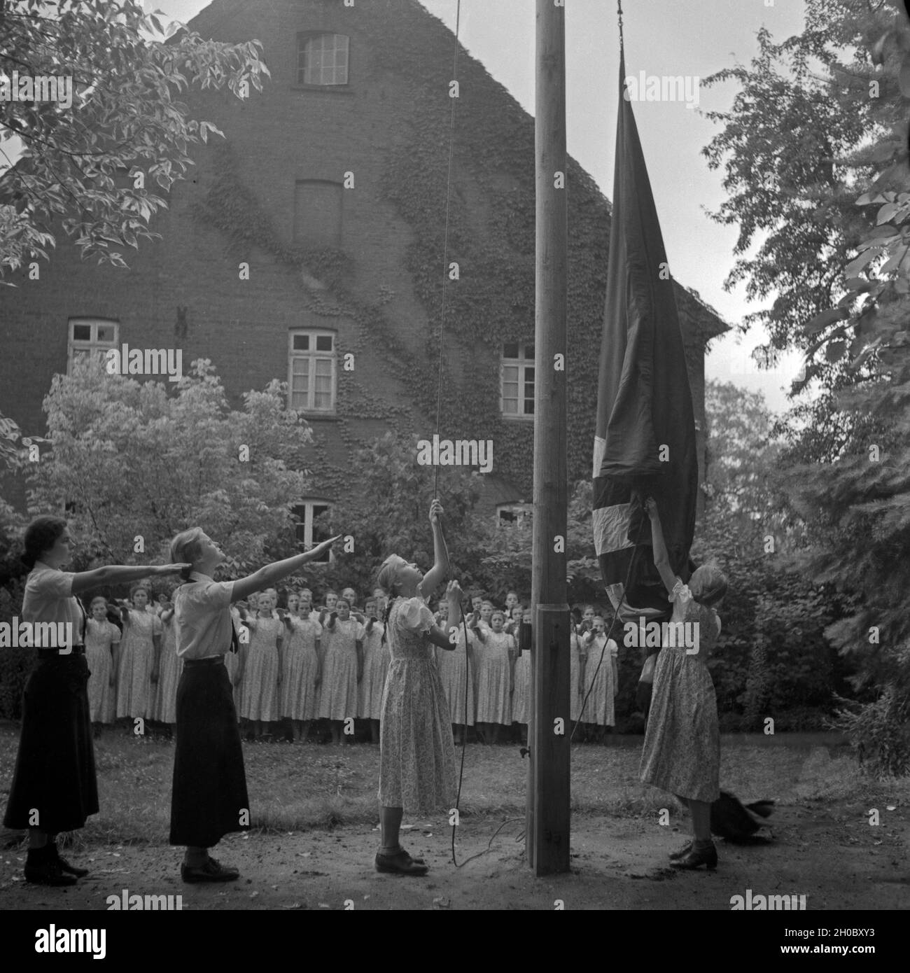 Morgendlicher Fahnenappell im Mädel Landjahr Lager in Polle an der Weser, Deutschland 1930er Jahre. Matutinal flag muster at the Hitler youth BdM camp at Polle, Germany 1930s. Stock Photo