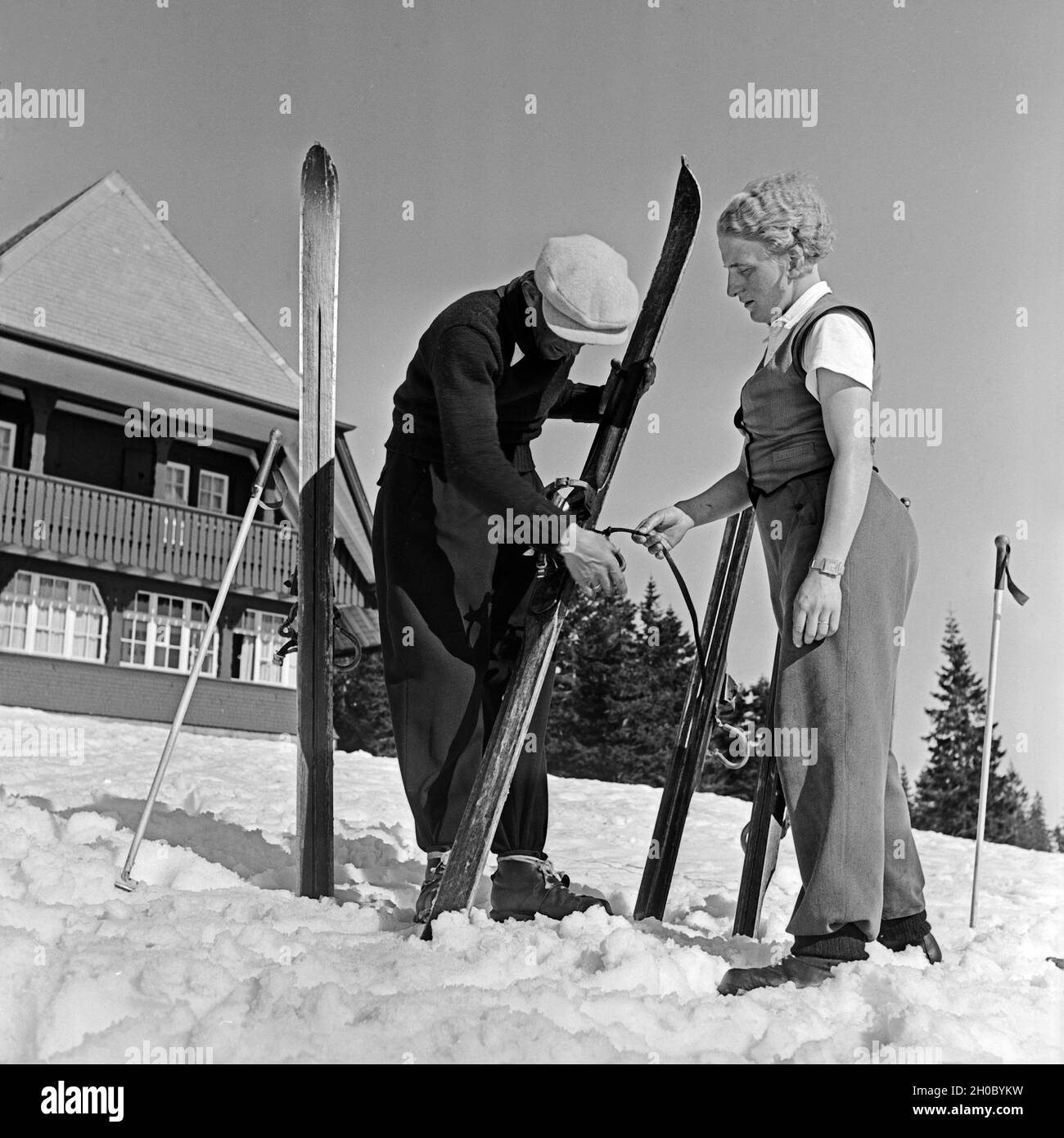 Zwei Skifahrer fachsimpeln über ihre Skier, Deutschland 1930er Jahre. Two ski tourists talking shop about their skis, Germany 1930s. Stock Photo