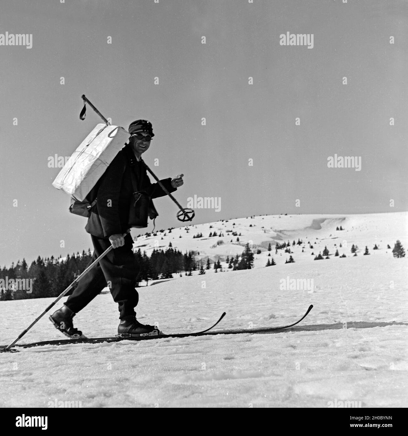 Im tief verschneiten Feldberggebiet kommt der Briefträger auf Skiern, Deutschland 1930er Jahre. In the deeply snowed in Feldberg area even the postman uses ski, Germany 1930s. Stock Photo