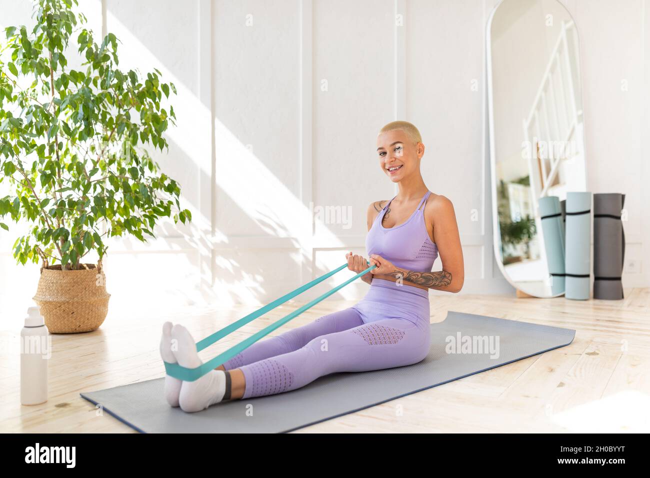 Young woman doing exercises with resistance bands in living room at home training with elastic band on yoga mat Stock Photo Alamy