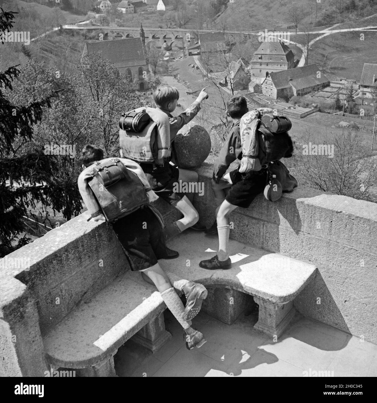 Drei Hitlerjungen schauen auf ein Dorf, Deutschland 1930er Jahre. Three Hitler youths watching a village from a  watchout, Germany 1930s. Stock Photo