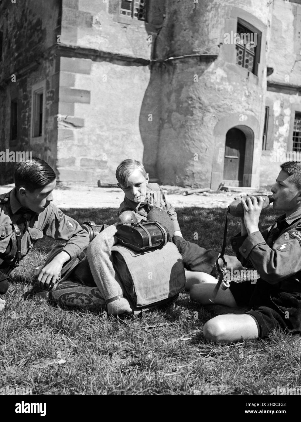 Drei Hitlerjungen rasten auf einer Wandertour in Rothenburg ob der Tauber, 1930er Jahre. Three Hitler youths resting at Rothenburg ob der Tauber, 1930s. Stock Photo