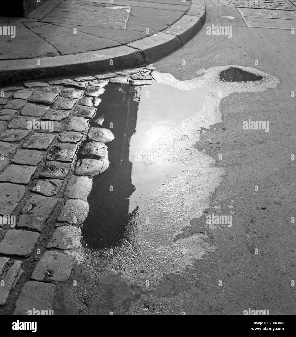 Eine Pfütze in einer Straße in Braunschweig, Deutschland. A puddle in the streets of Braunschweig, Germany. Stock Photo
