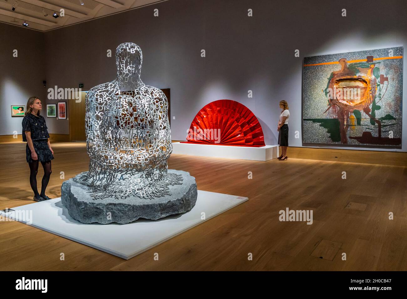 London, UK. 12th Oct, 2021. Jaume Plensa, Shadows I, 2006, est £180,000-250,000 and, in the background, Kazuo Shiraga (1924-2008), Untitled (Red Fan), 1965, Estimate: £1,000,000-1,500,000 (One of only a handful of sculptural works created by Kazuo Shiraga, and the only one to appear at auction) - Preview of the Post-War & Contemporary Art sale at Bonhams New Bond Street, London. The sale is on Friday 15 October Credit: Guy Bell/Alamy Live News Stock Photo