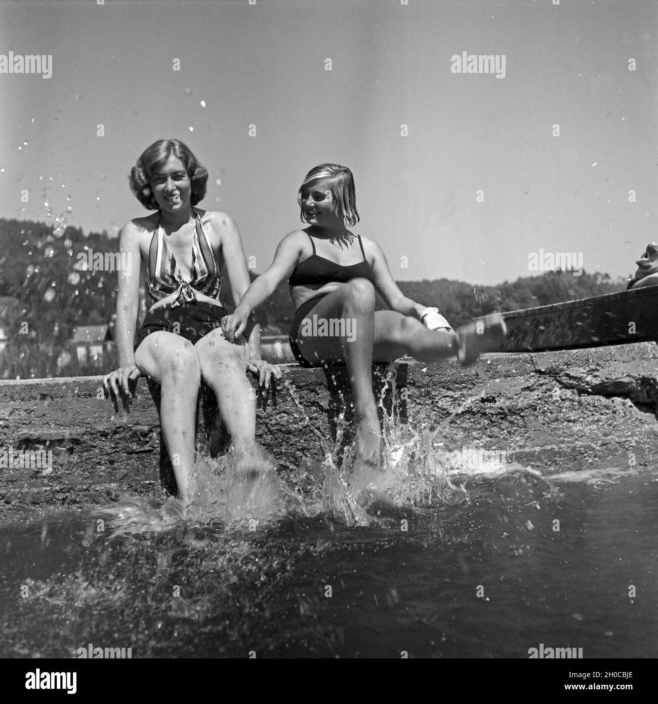 Badende planschen an einem Ufer eines Sees in Österreich, 1930er Jahre. Bathing splashing around at the entrance to a lake in Austria, 1930s. Stock Photo