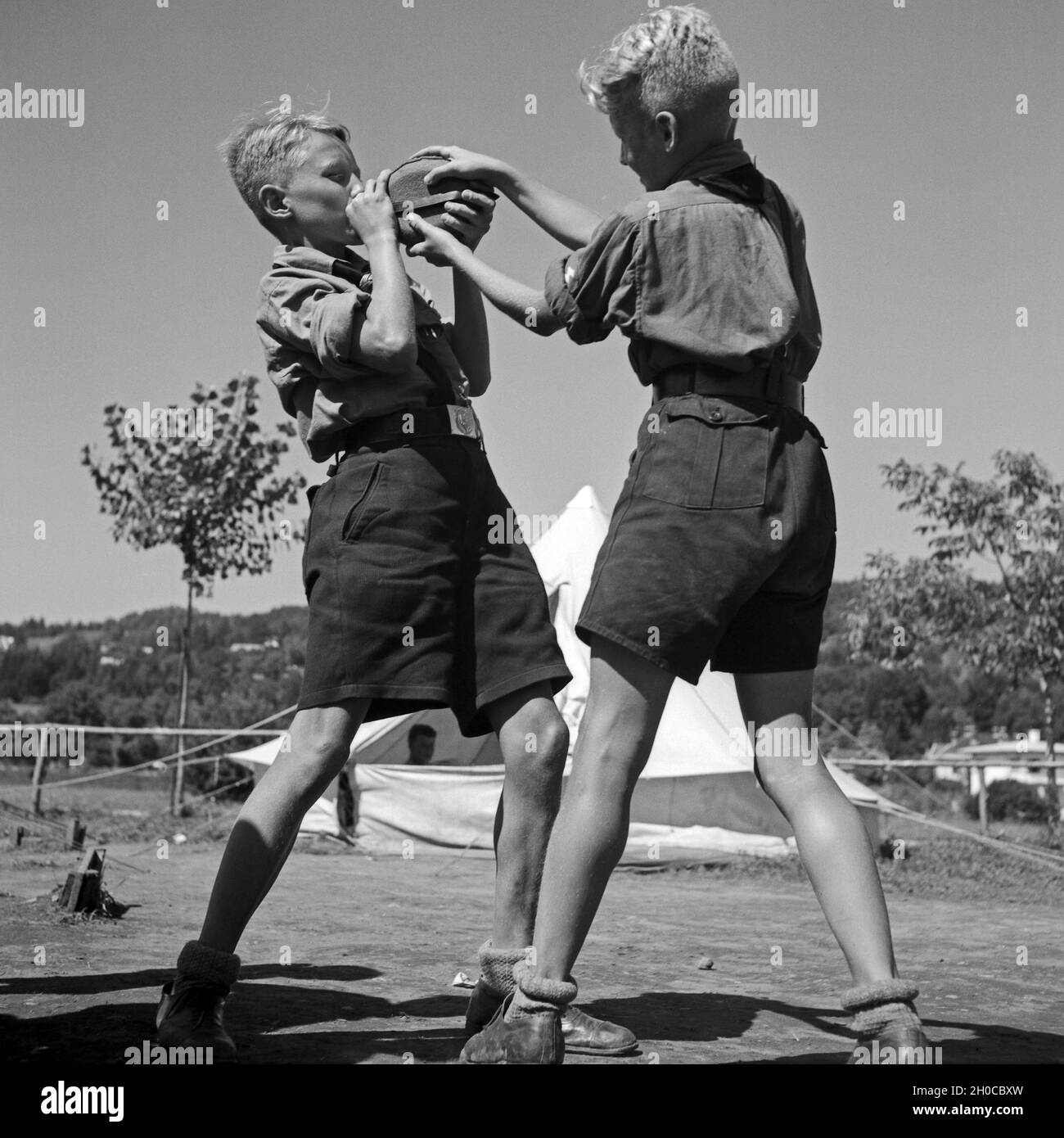 Zwei durstige Hitlerjungen streiten um die Wasserflasche im Hitlerjugend Lager, Österreich 1930er Jahre. Two thirsty Hitler youth quarreling for a bottle of water at the Hitler youth camp, Austria 1930s. Stock Photo