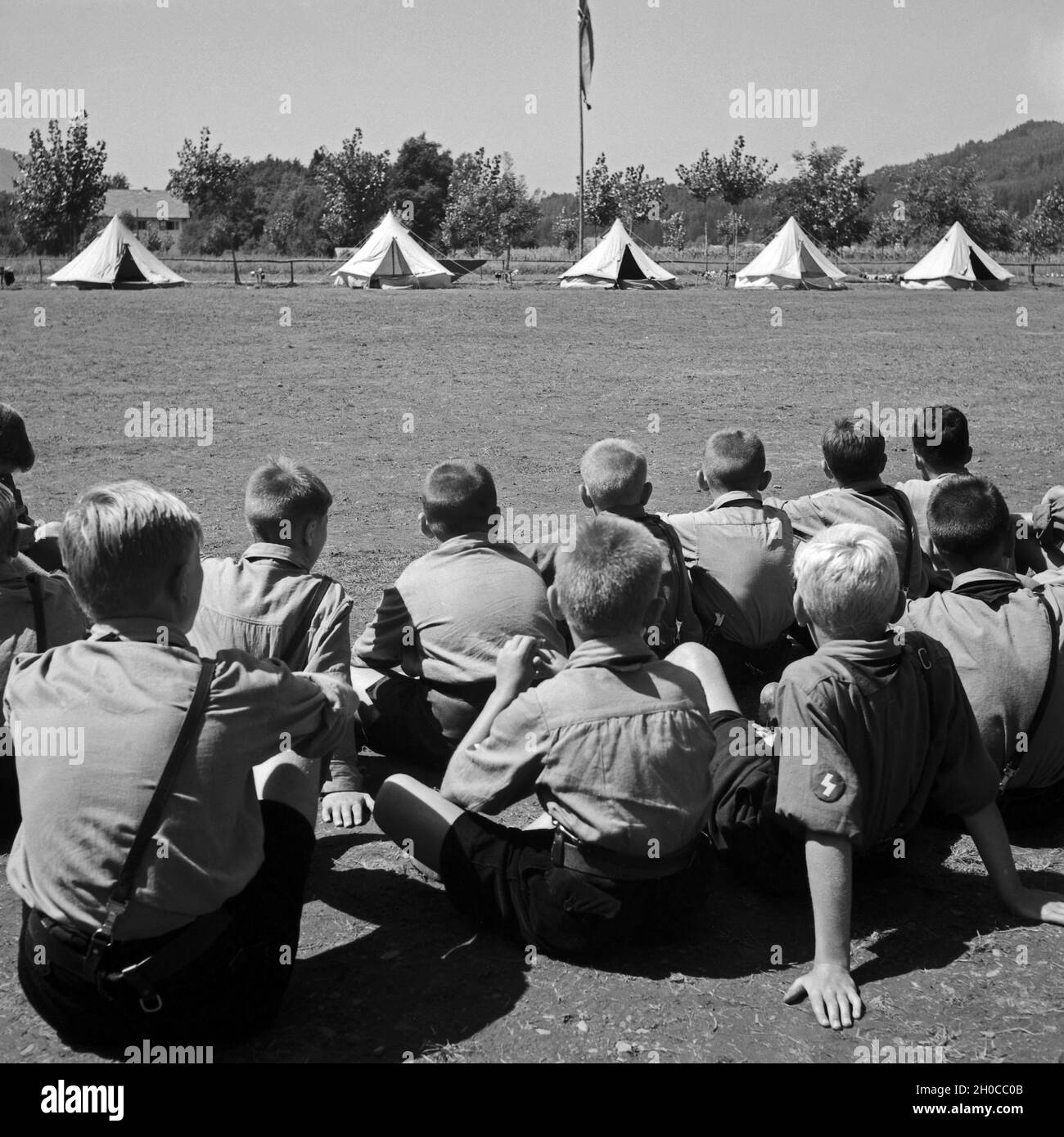 Pimpfe sitzen auf dem Platz vor ihren Zelten im Hitlerjugend Lager, Österreich 1930er Jahre. Hitler youth recruits sitting at the square in front of their tents at the camp, Austria 1930s. Stock Photo