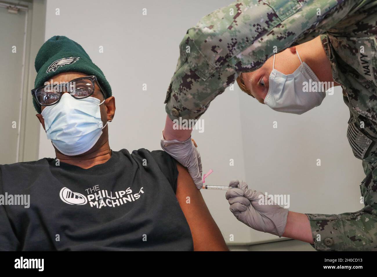 210121-N-CM812-002  Hospital Corpsman Mason Pruitt administers the first round of the Moderna COVID-19 Vaccine to Naval Surface Warfare Center Indian Head Division Explosive Ordnance Disposal Department Machinist Earnest Gibbs at the Morale, Welfare and Recreation's Mix House, Jan. 21. Stock Photo