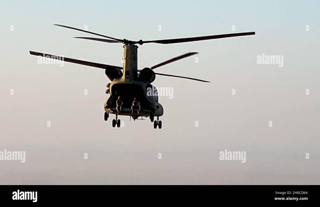 A CH-47 Chinook helicopter, operated by Soldiers with Bravo Company, 3-238th General Support Aviation Battalion, 28th Expeditionary Combat Aviation Brigade, flies over the 28th ECAB's area of operations in the Middle East during a routine flight mission. Stock Photo