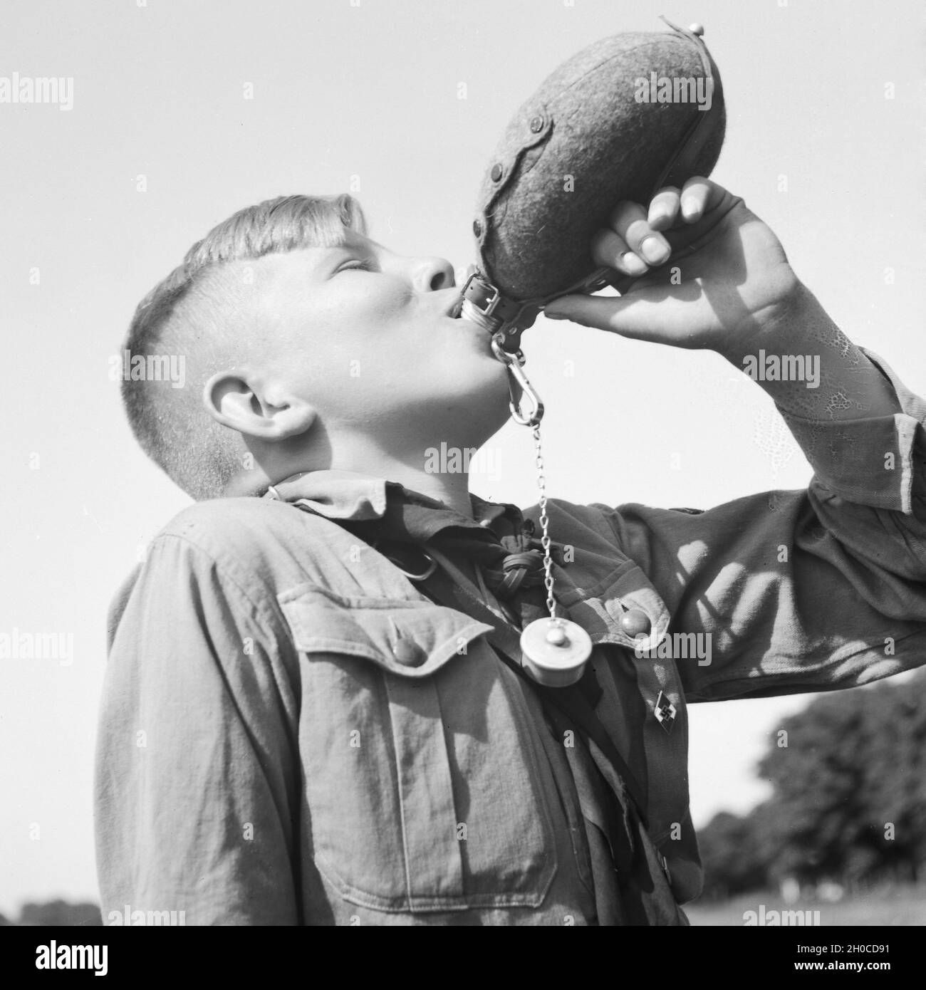 Ein Hitlerjunge nimmt einen Schluck aus seiner Feldflasche, Deutschland 1930er Jahre. A Hitler youth drinking from his waterbottle, Germany 1930s. Stock Photo