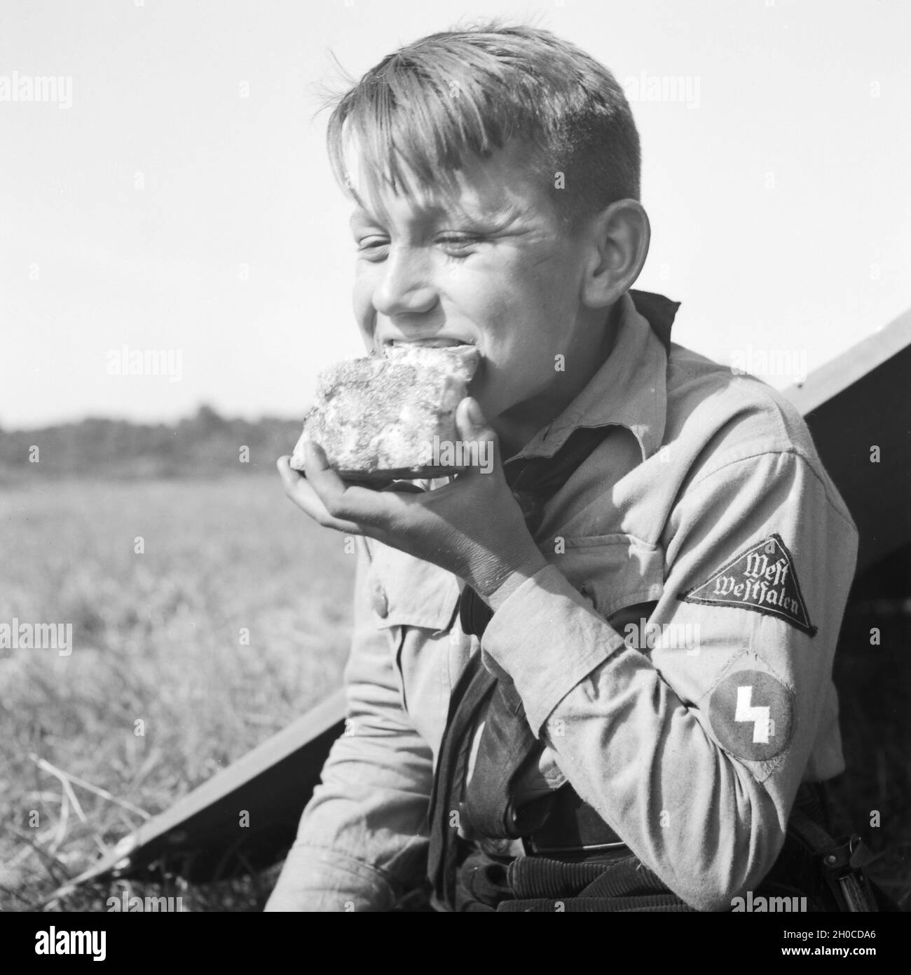 Hitlerjunge im Zeltlager beim Essen, Deutschland 1930er Jahre. Hitler youth having lunch, Germany 1930s. Stock Photo