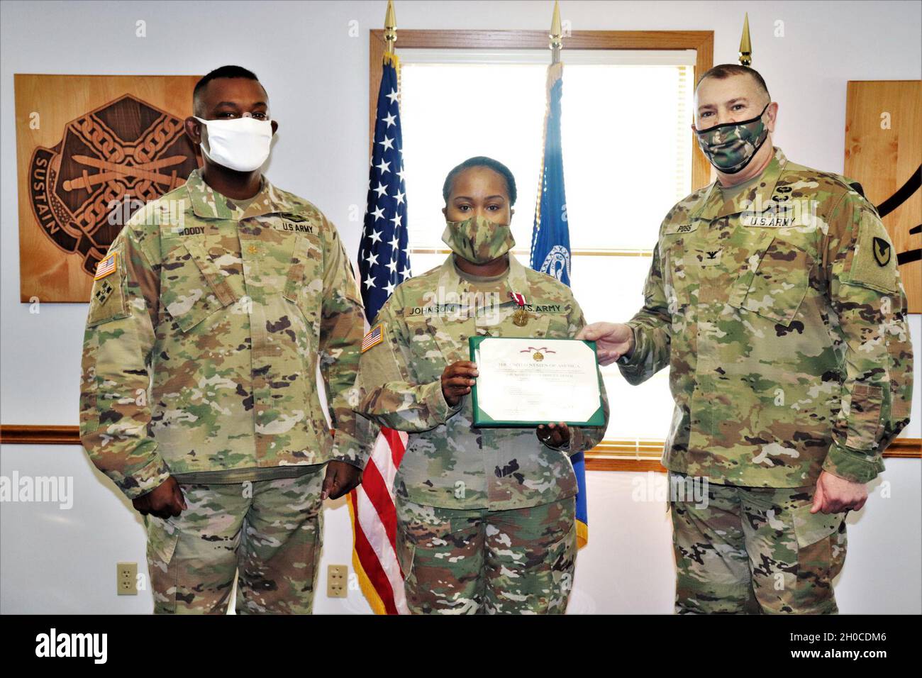 Fort McCoy Garrison Commander Col. Michael D. Poss (right) presents Master Sgt. Cynthia P. Johnson with an Army Meritorious Service Medal on Jan. 22, 2021, at the garrison headquarters building at Fort McCoy, Wis. Johnson earned the medal for meritorious service with Fort McCoy Garrison between 2018 and 2021. Also pictured is Maj. Eddie Woody, Fort McCoy Garrison Headquarters and Headquarters Company commander. Stock Photo