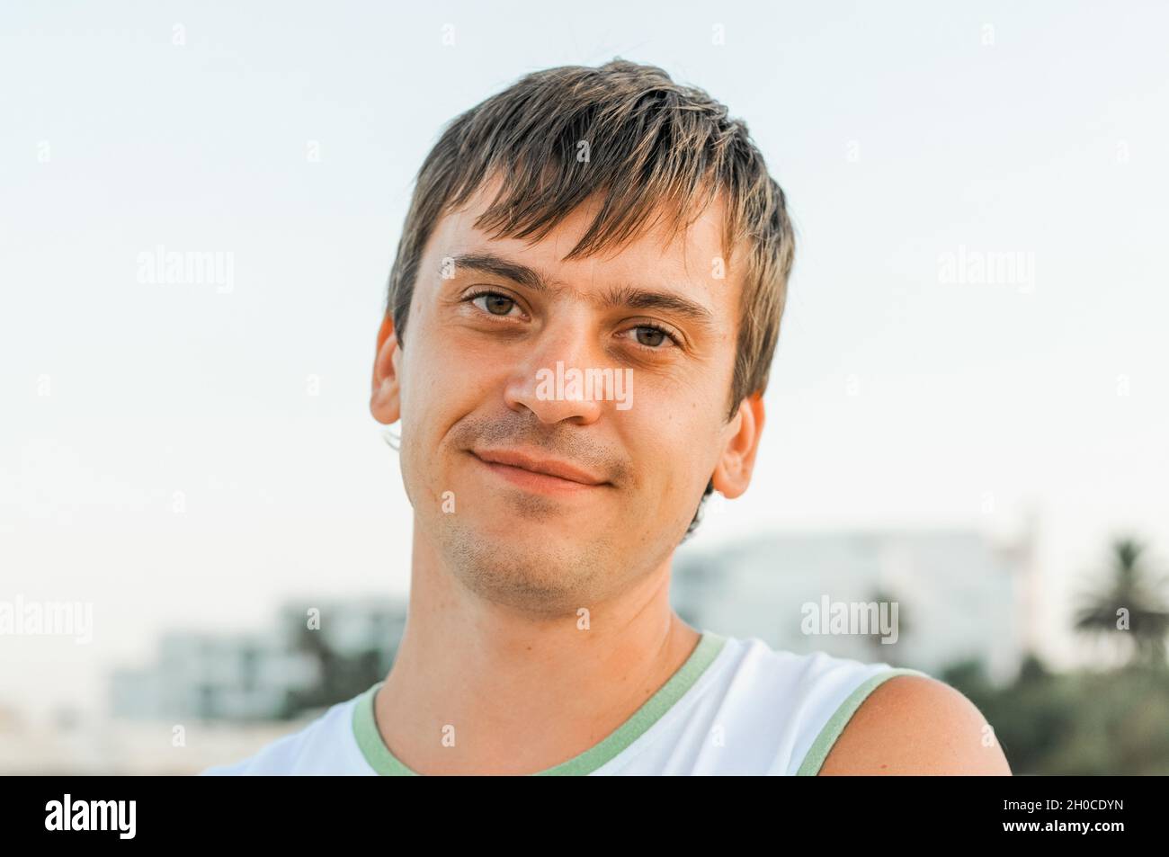 portrait of the face of a thirty year old adult candid caucasian happy man or a guy solo traveling on a summer vacation Stock Photo