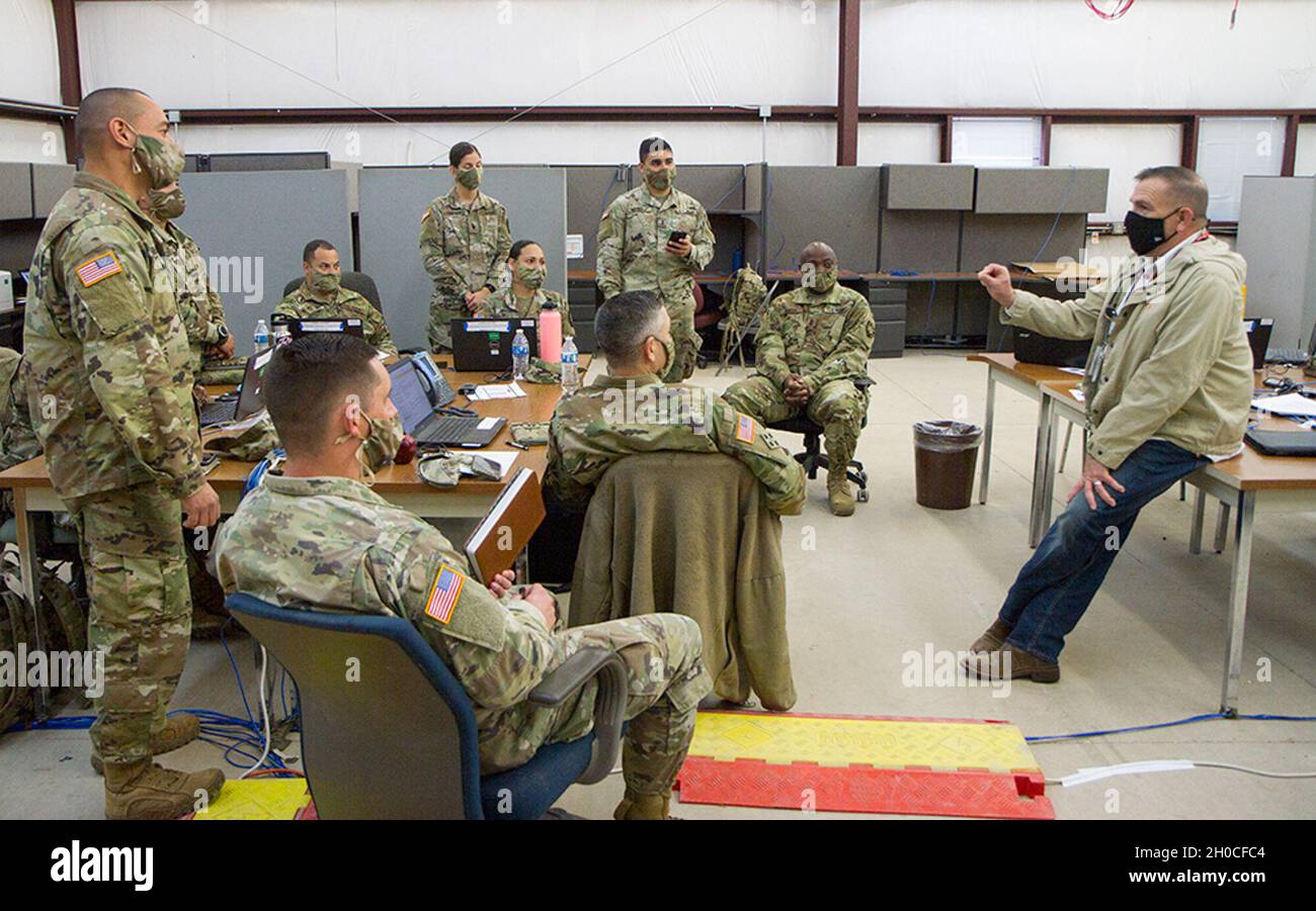 James McGarry (far right) addresses Soldiers in the S-4 section of the 50th Regional Support Group (RSG) during an initial planning team meeting about new requirements during the 50th RSG’s culminating training exercise at Fort Hood, Texas, on Jan. 22, 2021. McGarry is a forward operator for the logistics civilian augmentation program, who is preparing them to provide management and base operations during their deployment to Poland. The 50th RSG is a Florida Army Guard unit based in Homestead, Florida. Stock Photo