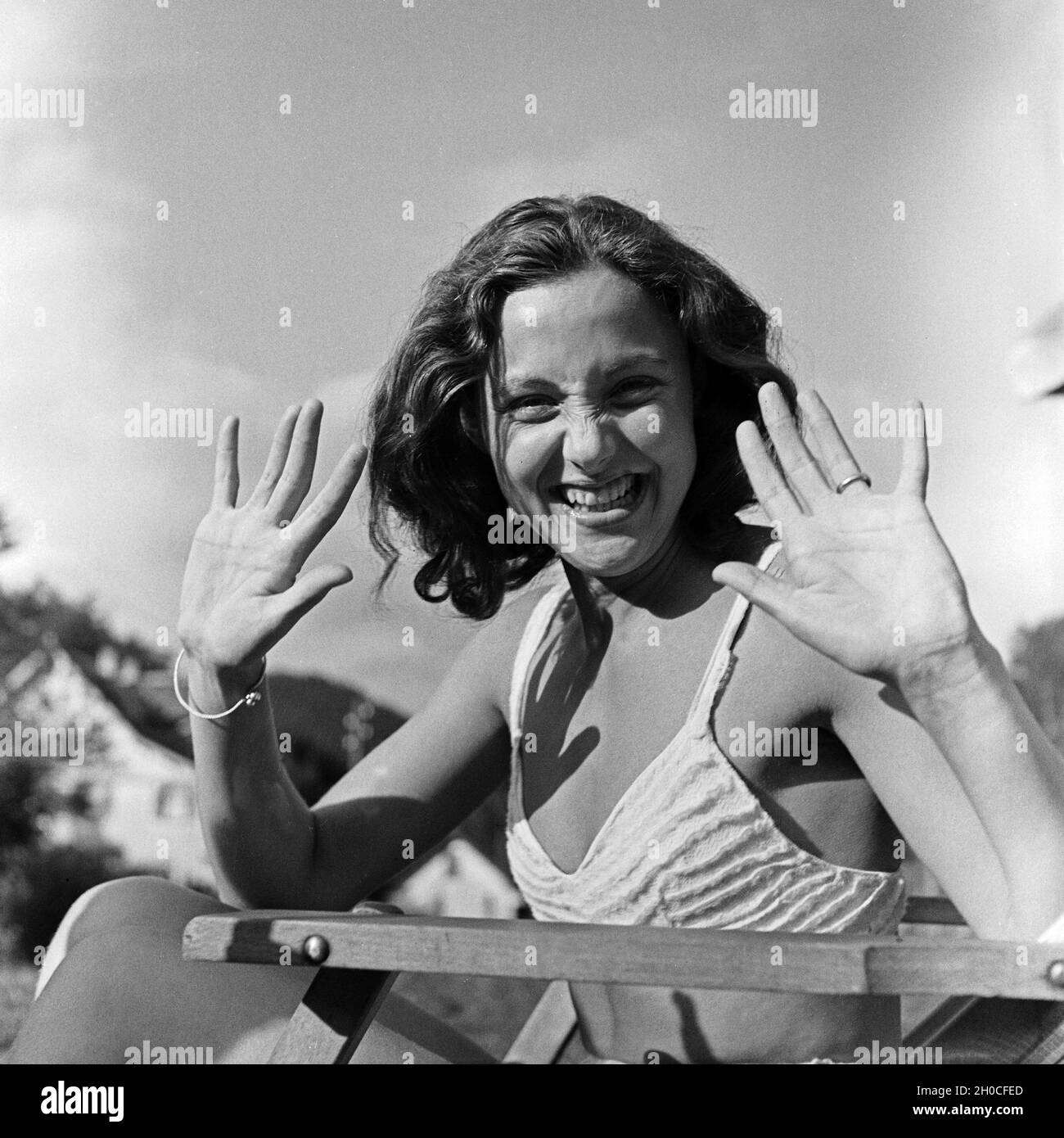 Eine junge Frau beim Sonnenbad am Schwimmbecken, Deutschland 1930er Jahre. A young woman posing while sunbathing at the pool, Germany 1930s. Stock Photo