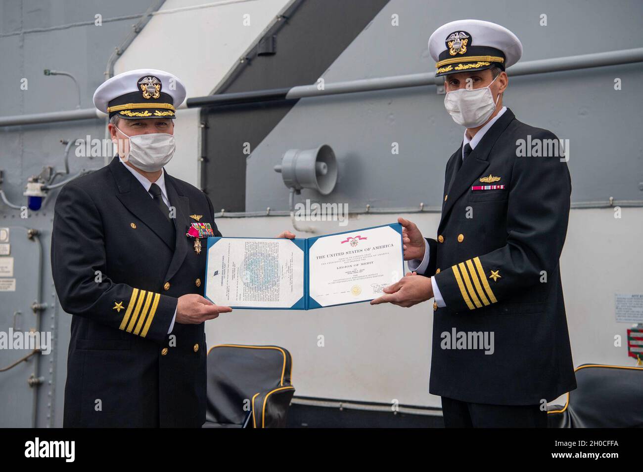 SAN DIEGO (Jan. 22, 2021)  Capt. John Barnett, commodore of Amphibious Squadron (PHIBRON) 1, right, presents the legion of merit to Capt. Aaron Kelley, commanding officer of the Wasp-class amphibious assault ship USS Essex (LHD 2), during a change of command ceremony. Essex is homeported in San Diego. Stock Photo