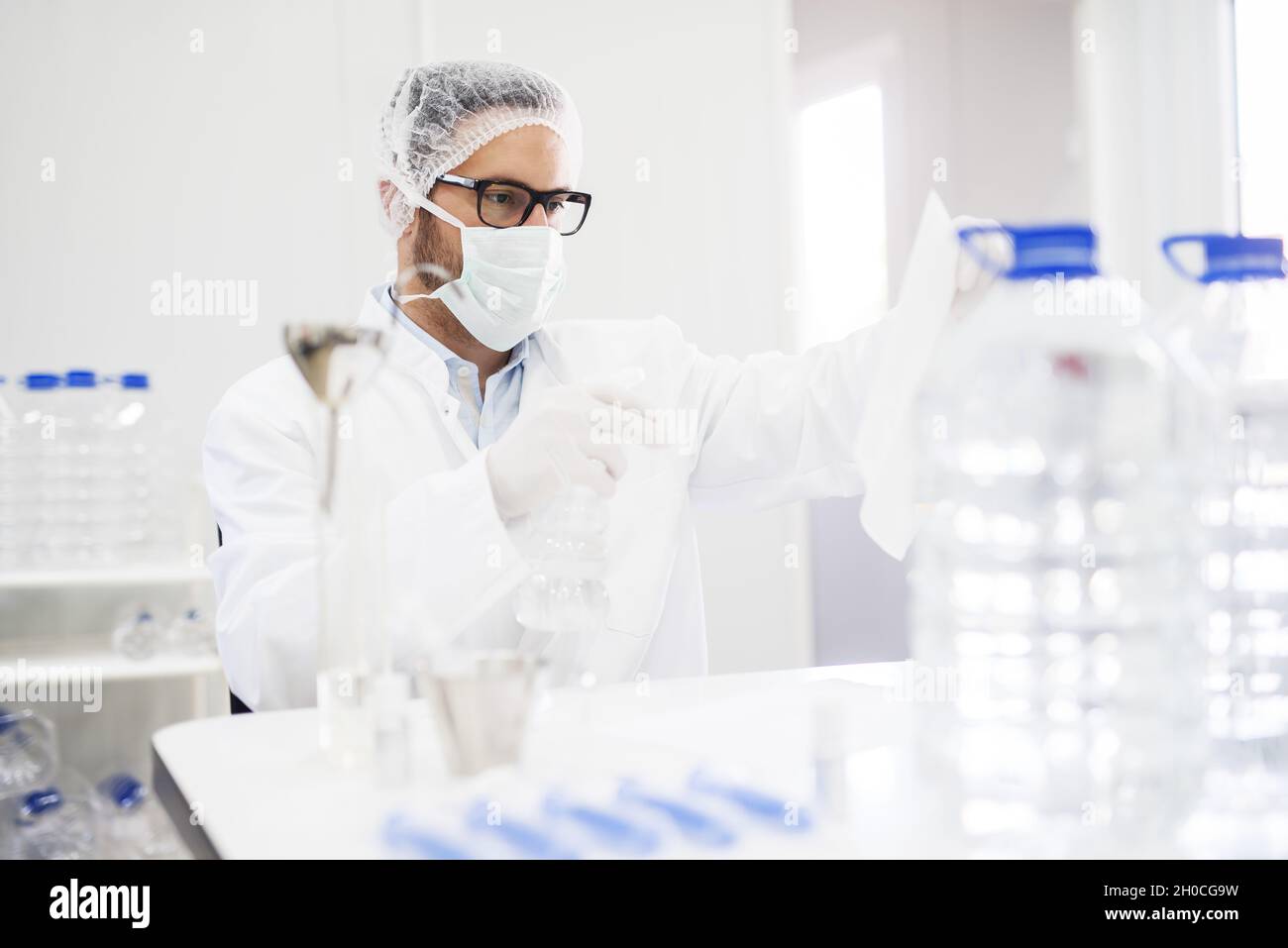 Scientist checking water quality at water factory. In front of him