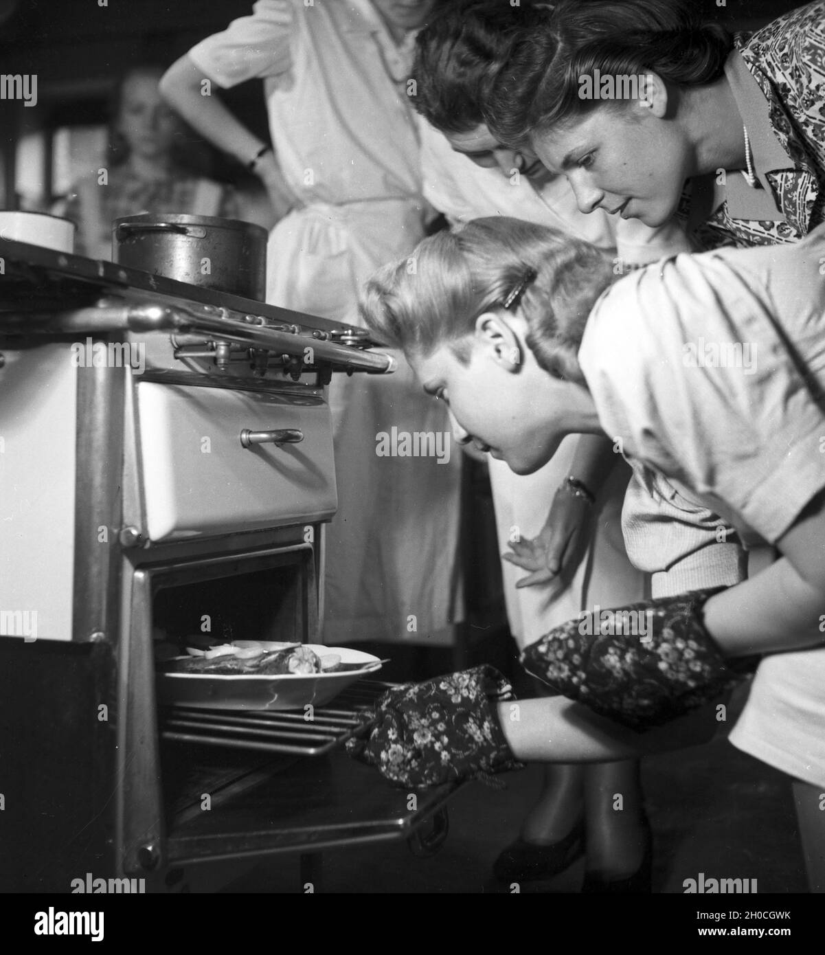 Frauen üben sich in der Hauswirtschaft in einer der BDM Arbeitsgemeinschaften 'Kochen', Deutschland 1930er Jahre. Women exercising and practizing domestic economy in one of the BDM workshops 'Kochen' ('cooking'); Germany 1930s. Stock Photo