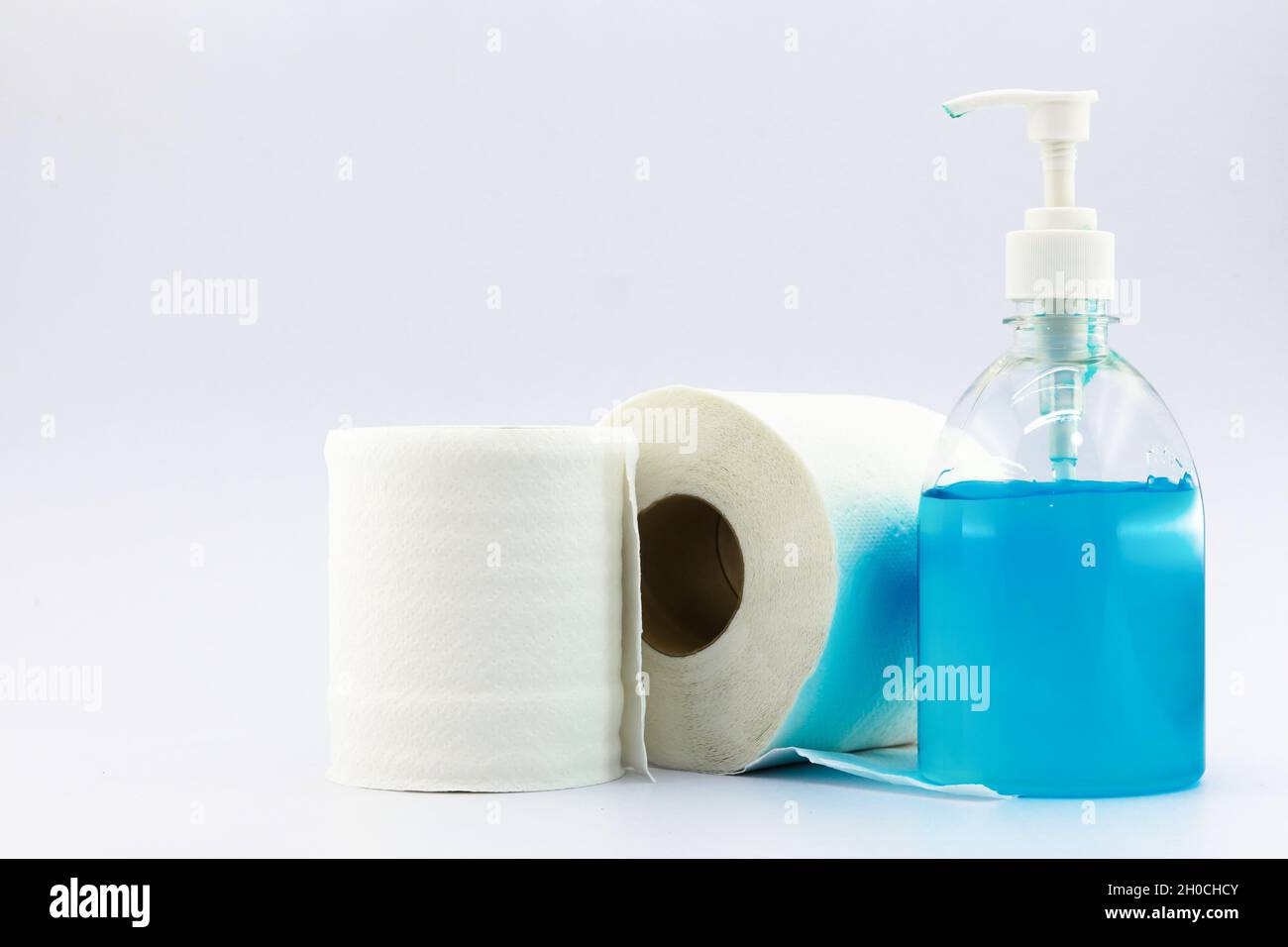 Toilet roll and sanitizer in pump bottle on white background. Copy ...