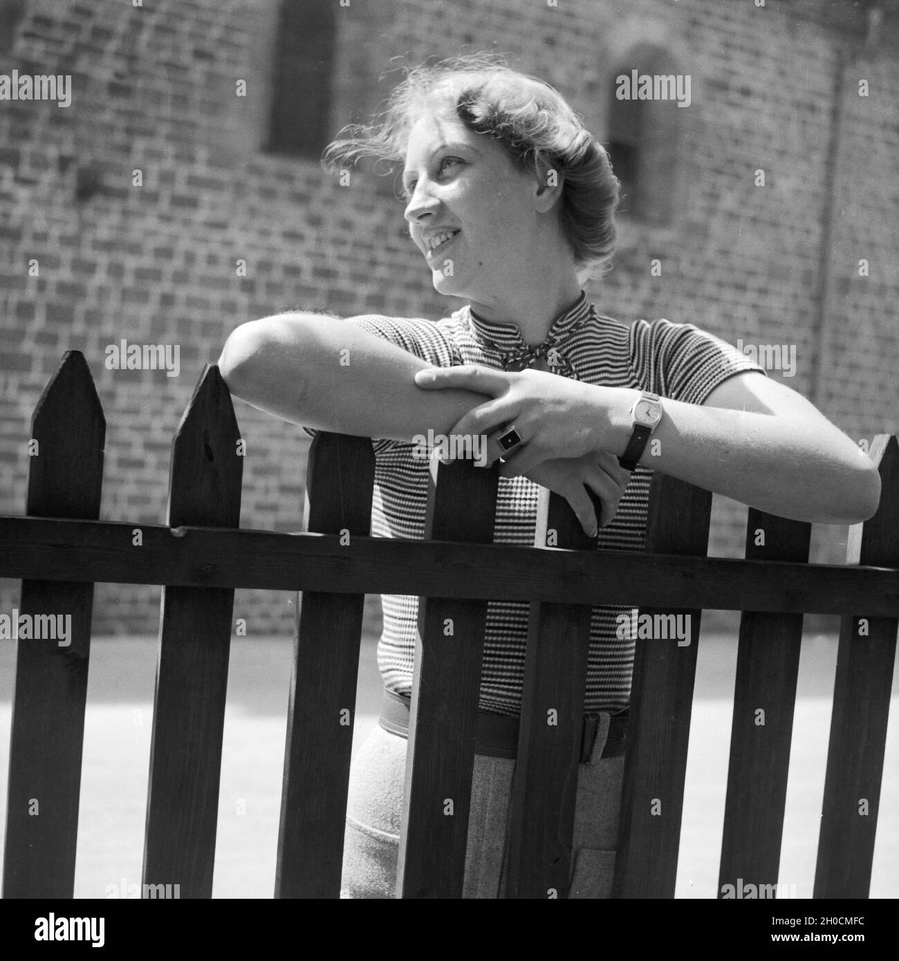Frau an einem Zaun, Deutschland 1930er Jahre. Woman by a fence, Germany ...