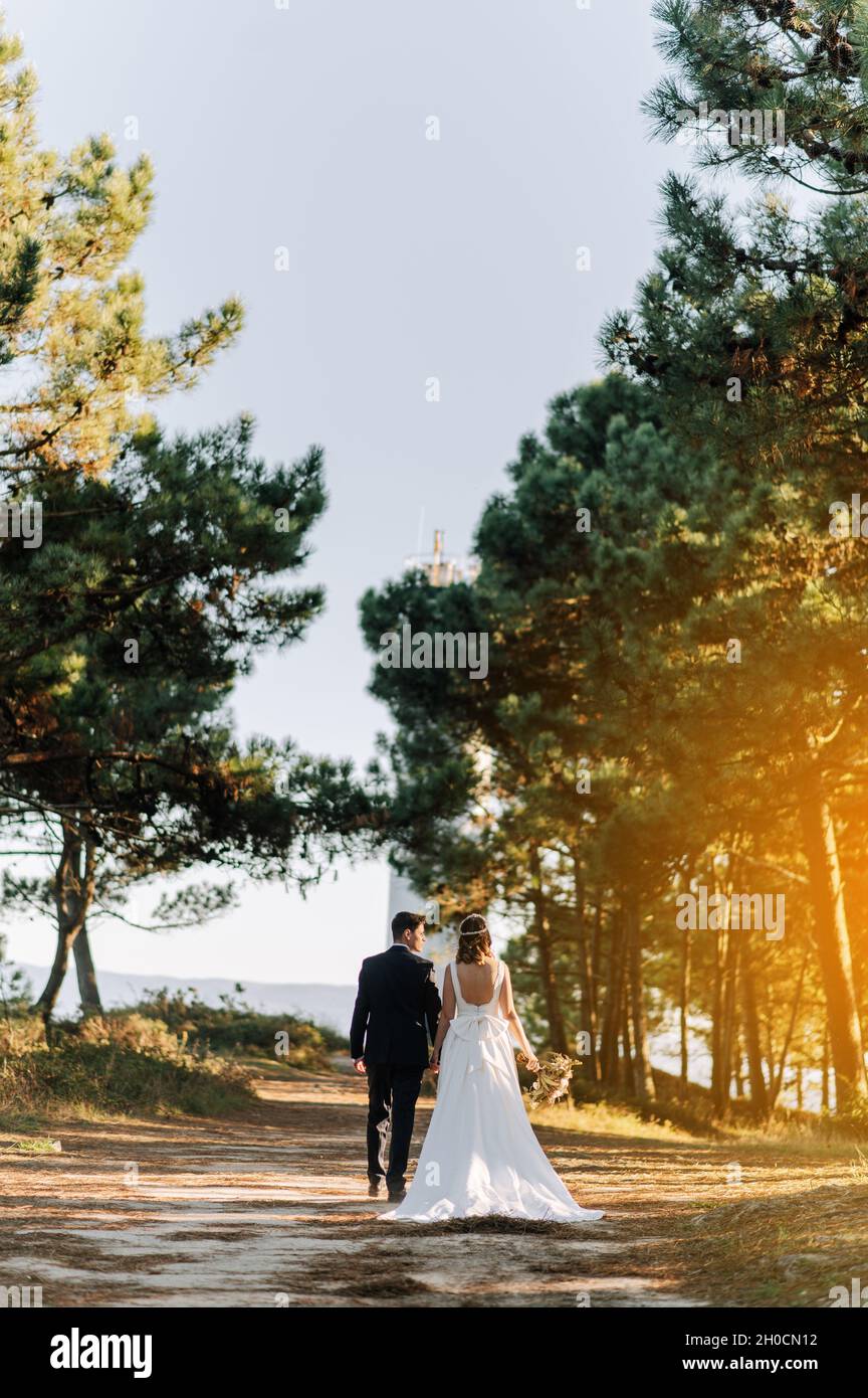 Just married couple walking on a forest at sunset Stock Photo - Alamy
