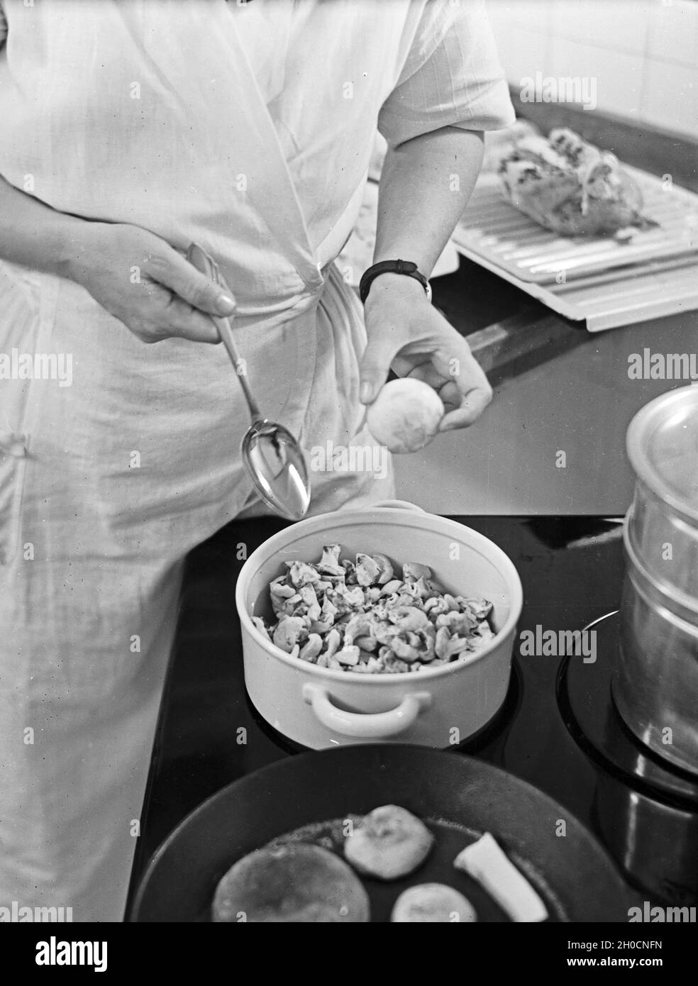 Eine Hausfrau bereitet eine leckere Mahlzeit aus gemischten Pilzen zu, Deutschland 1930er Jahre. A woman preparing a meal with mixed mushrooms, Germany 1930s. Stock Photo