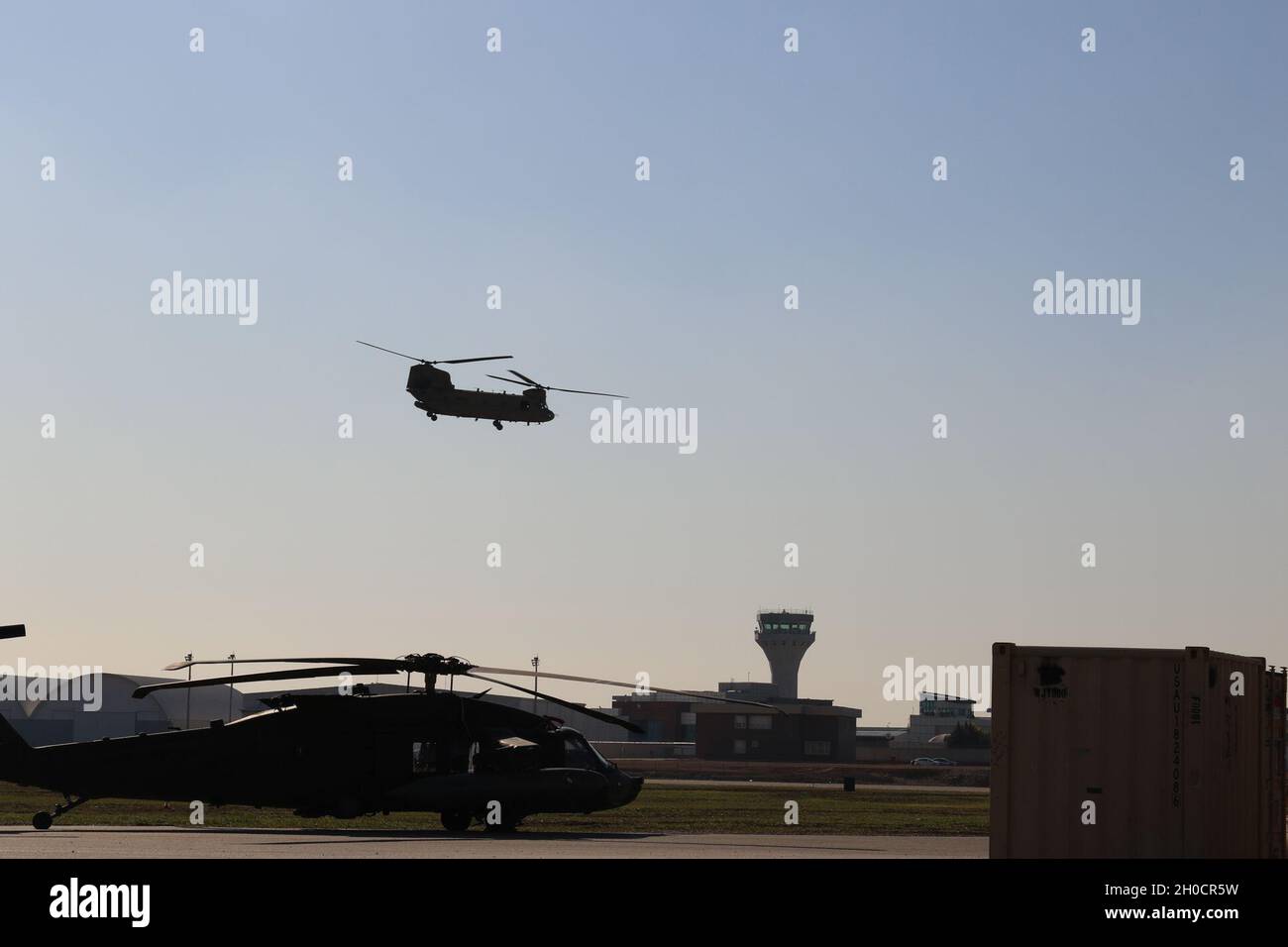 A CH-47 Chinook helicopter, operated by Soldiers with Bravo Company, 3-238th General Support Aviation Battalion, 28th Expeditionary Combat Aviation Brigade takes off for a flight mission from an airfield in the 28th ECAB's area of operations in the Middle East. Stock Photo