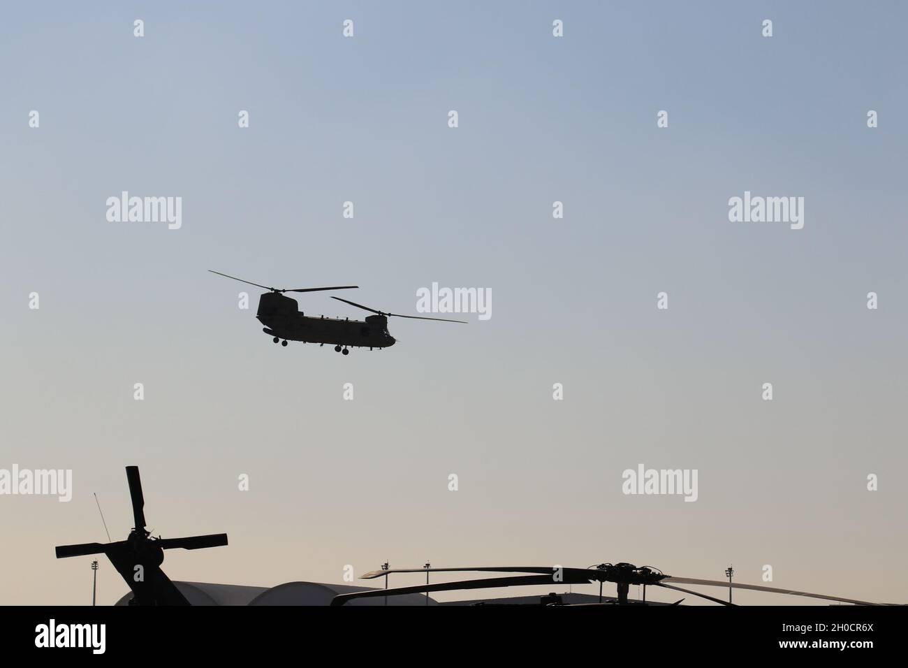 A CH-47 Chinook helicopter, operated by Soldiers with Bravo Company, 3-238th General Support Aviation Battalion, 28th Expeditionary Combat Aviation Brigade takes off for a flight mission from an airfield in the 28th ECAB's area of operations in the Middle East. Stock Photo