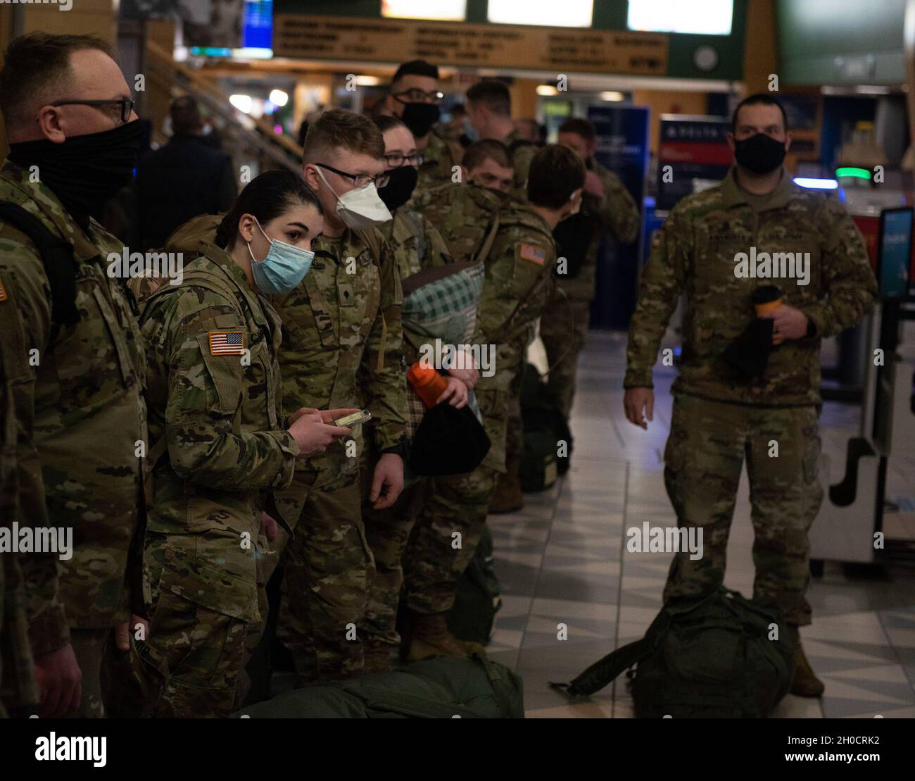 Soldiers with the Vermont National Guard's 172nd Law Enforcement Detachment wait to check their bags at Burlington International Airport in South Burlington, Vermont, Jan. 26, 2021. The Soldiers will deploy to the U.S. European Command area of responsibility to support Operation Freedom's Sentinel. Stock Photo