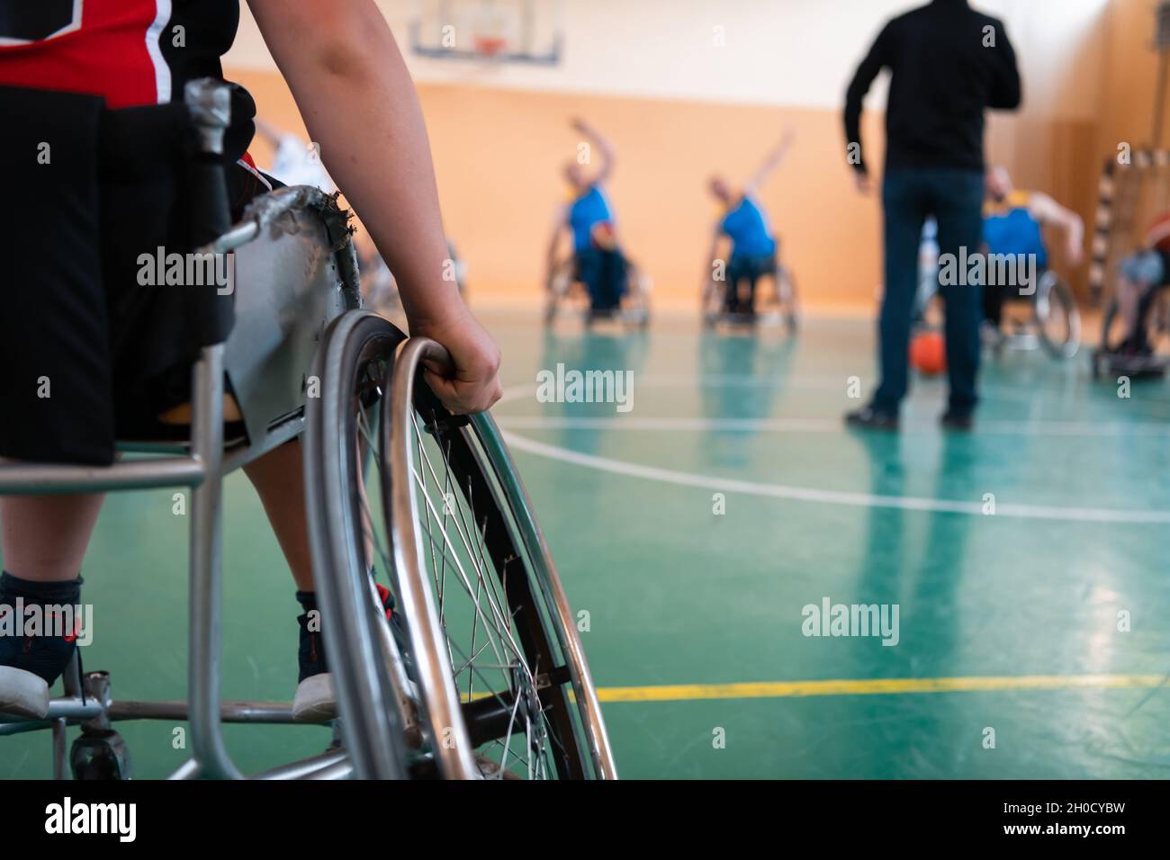 the selector of the basketball team with a disability stands in front of the players and shows