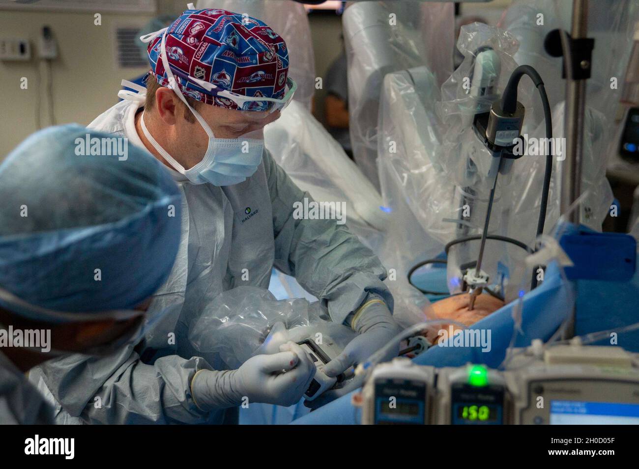 210127-N-LW757-1026  SAN DIEGO (Jan. 27, 2020) Jesse Bandle, a staff surgeon assigned to Naval Medical Center San Diego's (NMCSD) Main Operating Room (right), along with other surgical staff prepare a patient for a robotic-assisted laparoscopic inguinal hernia repair procedure in one of the hospital's operating rooms Jan. 27. Robotic surgical systems, like those used at NMCSD, allow surgeons to perform minimally-invasive procedures, and this procedure was performed during a remote, tele-mentoring study. NMCSD’s mission is to prepare service members to deploy in support of operational forces, d Stock Photo