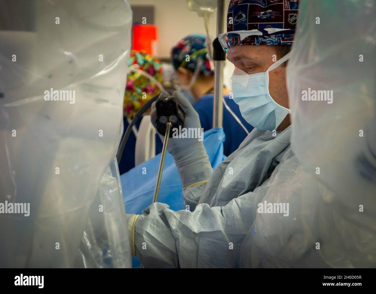 210127-N-LW757-1012  SAN DIEGO (Jan. 27, 2020) Jesse Bandle, a staff surgeon assigned to Naval Medical Center San Diego's (NMCSD) Main Operating Room, prepares a patient for a robotic-assisted laparoscopic inguinal hernia repair procedure in one of the hospital's operating rooms Jan. 27. Robotic surgical systems, like those used at NMCSD, allow surgeons to perform minimally-invasive procedures, and this procedure was performed during a remote, tele-mentoring study. The COVID-19 pandemic has changed the way many facets of healthcare are conducted, and NMCSD has adapted some of its techniques an Stock Photo