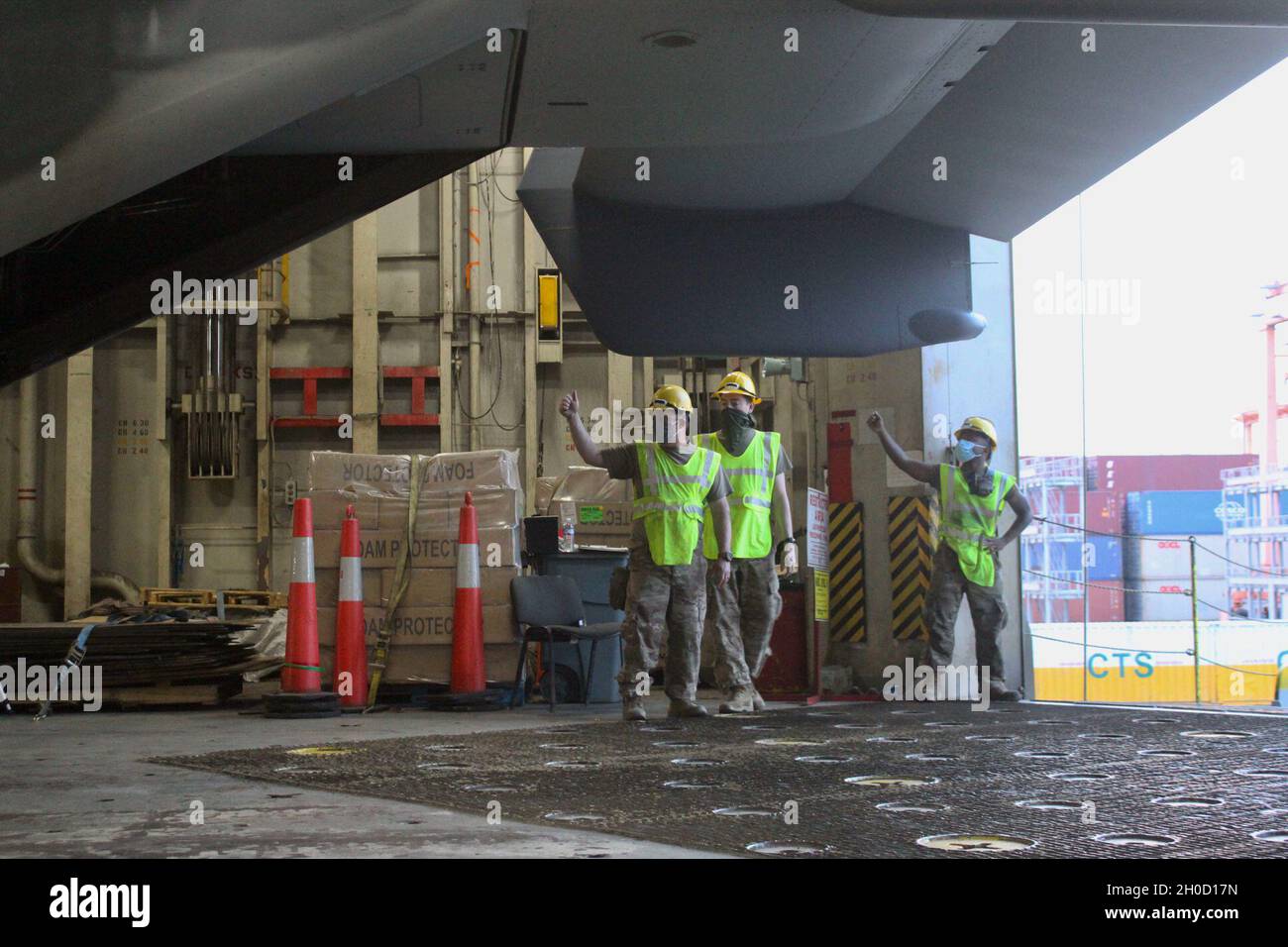 Air Force mechanics guide the movement of a CV-22 Osprey aboard the ...