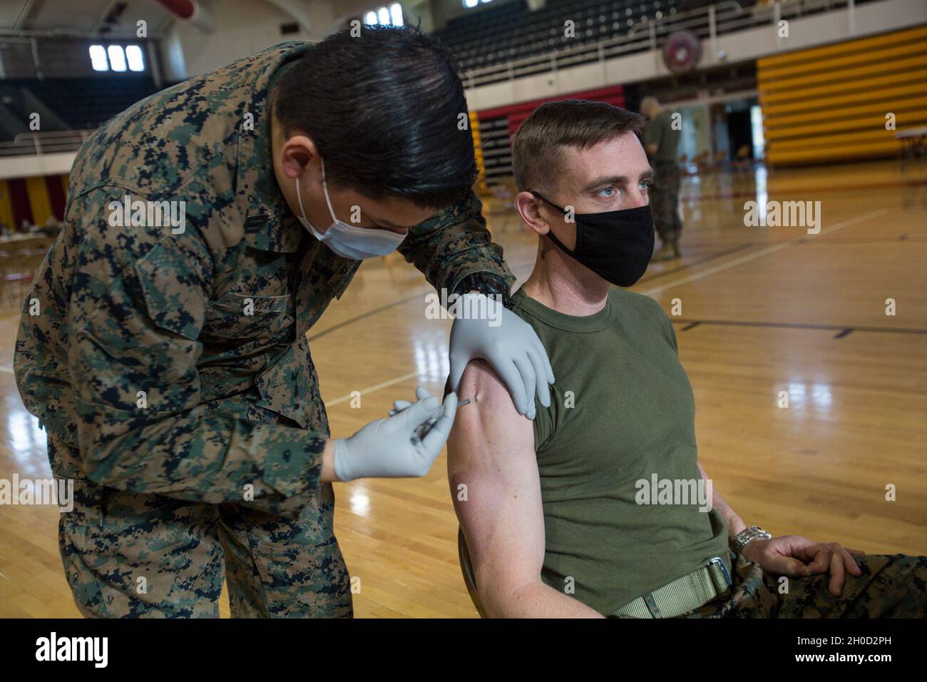 U.S. Marine Corps Lt. Col. Charles Nash, battalion commander of 3rd Battalion, 2nd Marine Regiment, 2d Marine Division, receives a COVID-19 vaccine at Camp Lejeune, N.C., Jan. 28, 2021. The Department of Defense plans to administer its initial allocation of 43,875 doses of the COVID-19 vaccine to continental United States and outside continental United States overseas populations of DoD uniformed service members, both active and Selected Reserve components, including members of the National Guard, dependents; retirees, civilian employees, and select DoD contract personnel as authorized in acco Stock Photo