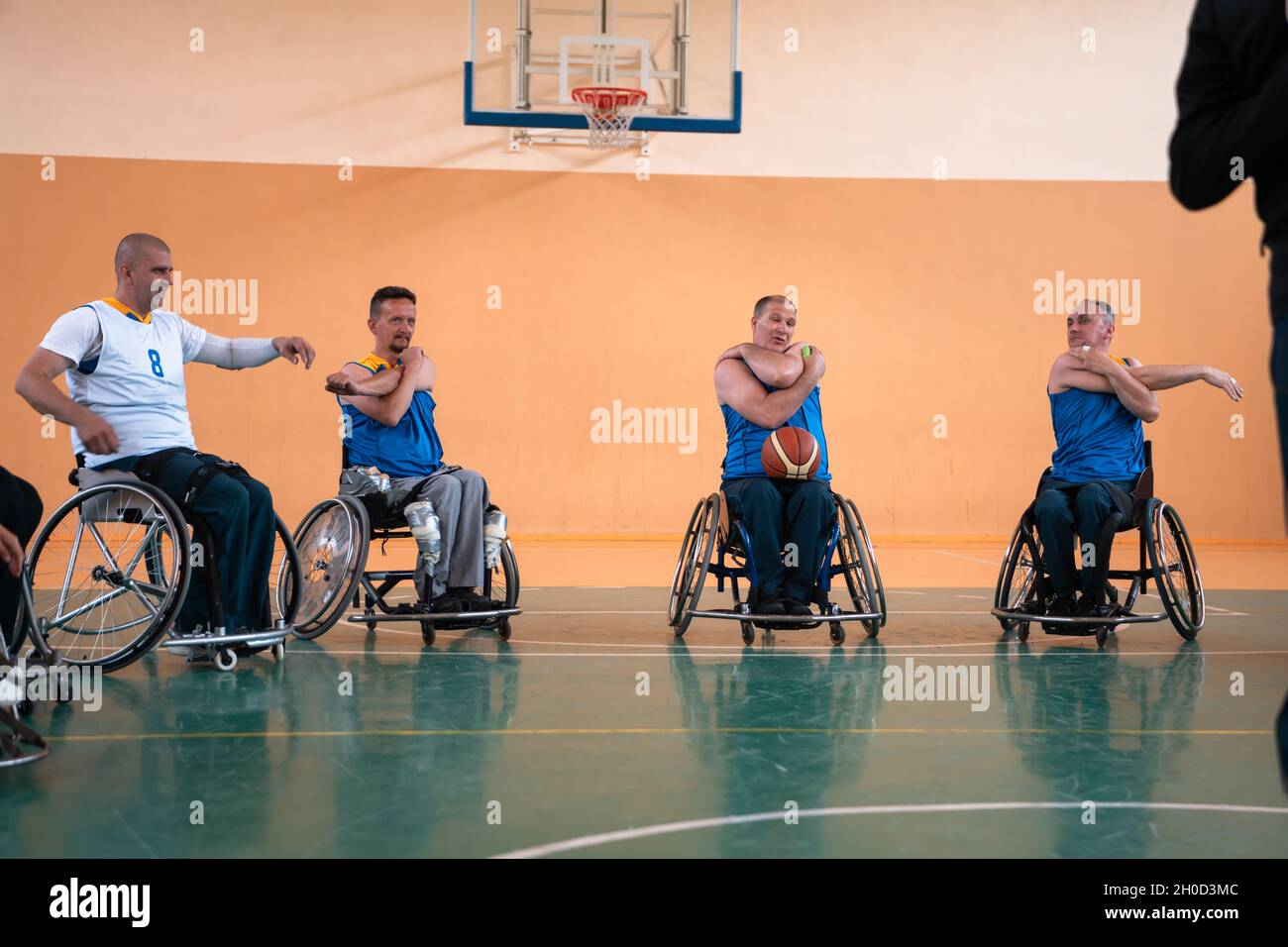 the selector of the basketball team with a disability stands in front of the players and shows