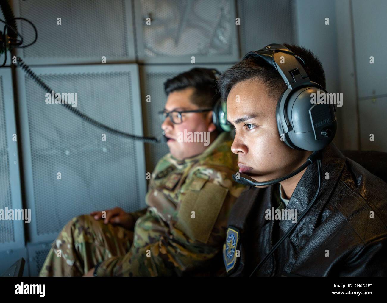 U.S. Air Force Senior Airman Philip Nadela, right, 9th Air Refueling Squadron KC-10 Extender boom operator, refuels an F-16C Fighting Falcon Jan. 28, 2021, over California as Staff Sgt. Alexis Martinez, 9th ARS boom operator, provides support. The F-16s are assigned to the 177th Fighter Wing in Egg Harbor Township, New Jersey. Stock Photo