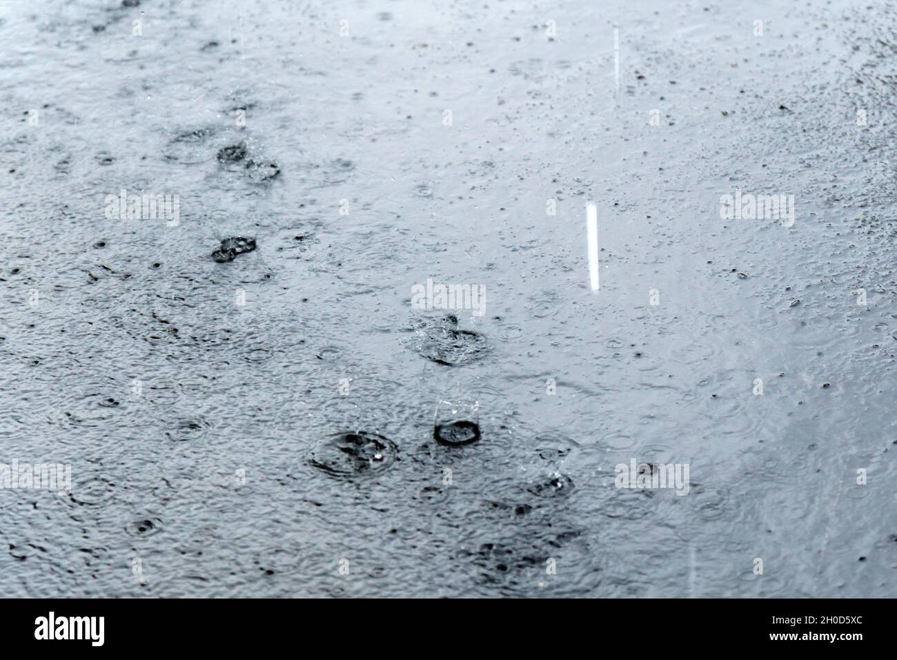 Raindrops falling on puddle hi-res stock photography and images - Alamy