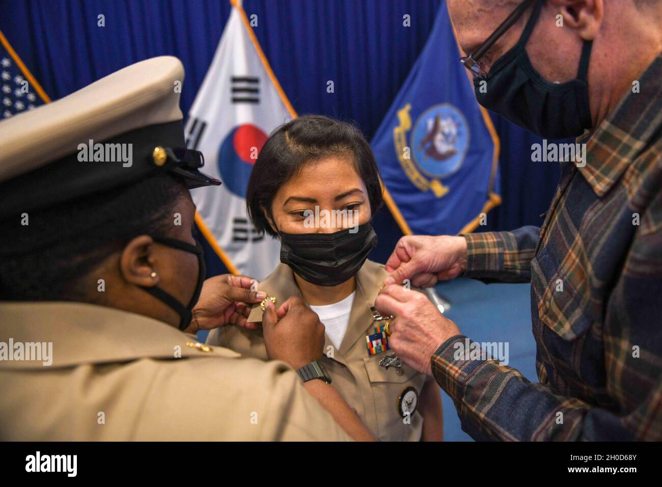 210129-N-ZU710-0144 CHINHAE, Republic of Korea (Jan. 29, 2021) Chief Navy Career Counselor Atit Gurung gets her anchor rank insignia pinned to her collars during an annual Navy Chief Petty Officer Pinning Ceremony at Commander, Fleet Activities Chinhae. The Navy Chief Petty Officer Pinning Ceremony is a tradition unique to the Navy, which dates back to 1893, and signifies a new position of leadership and responsibility for the Navy. Stock Photo