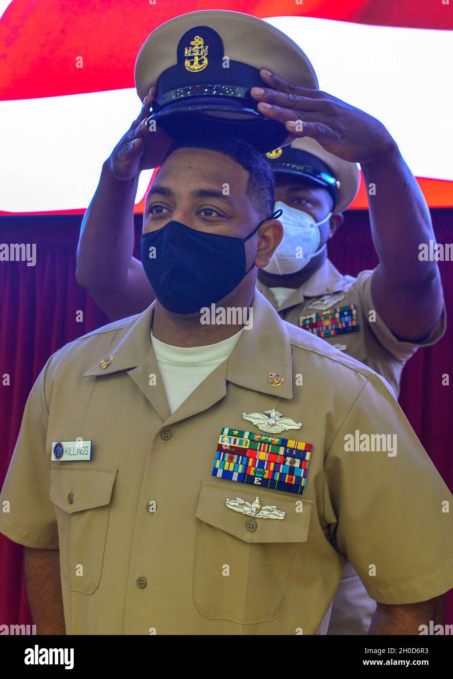 210129-N-NH199-1180  SAN DIEGO (Jan. 29, 2021) Chief Hospital Corpsman Anthony Killings receives his combination cover from his sponsor during a chief petty officer pinning ceremony on board Navy Medicine & Readiness Training Center San Diego (NMRTC) Jan. 29. Due to the COVID-19 pandemic, the ceremony was livestreamed via video teleconference (VTC) and Facebook Live allowing family, friends and staff to participate while adhering to social distancing guidelines set forth from the Centers for Disease Control (CDC). The COVID-19 pandemic has changed the ways of how to conduct business and NMRTC Stock Photo