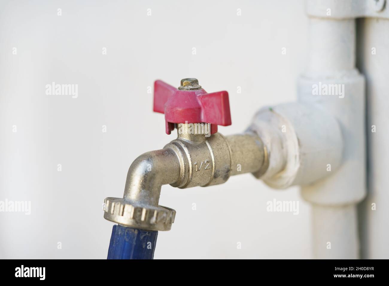 half inch water tap white wall with a hose attached Stock Photo - Alamy