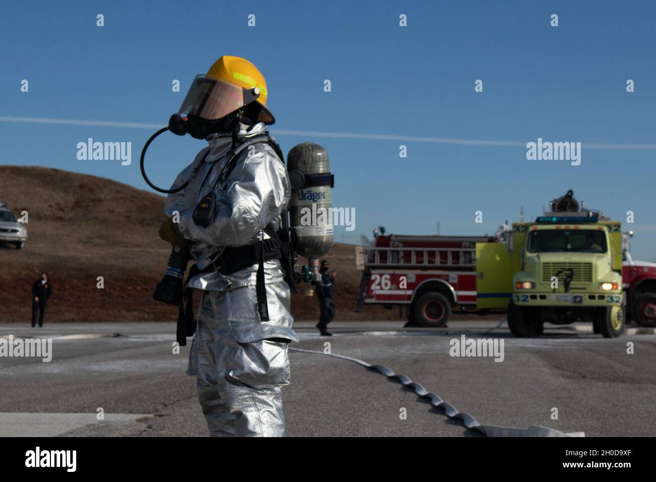 A member of the Camp Bondsteel Fire Department stands ready with a water hose to put out a simulated burning UH-60 Blackhawk during a pre-accident plan rehearsal at the Camp Bondsteel air refueling point Jan. 29, 2021. Aviation personnel, military police, refuelers and the CBFD responded to the simulated aircraft emergency. After a fuel line broke and started the aircraft on fire, the CBFD safely extinguished the fire, allowing them to extract the simulated casualties from the aircraft. Stock Photo