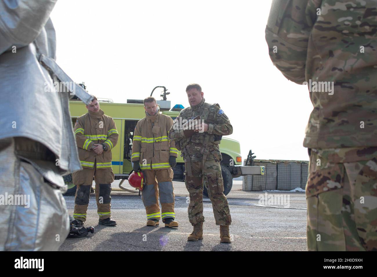 Chief Warrant Officer 3 Lee Fuller, aviation safety officer assigned to Regional Command-East, Kosovo Force talks with the Camp Bondsteel Fire Department following a pre-accident plan rehearsal at the Camp Bondsteel air refueling point Jan. 29, 2021. Aviation personnel, military police, refuelers and the CBFD responded to a simulated aircraft emergency involving a UH-60 Blackhawk. The forward arm and refueling point where the rehearsal was conducted is one of the areas where aviation crew members assume the most risk. Regular training reduces that risk, minimizes equipment damage and saves liv Stock Photo