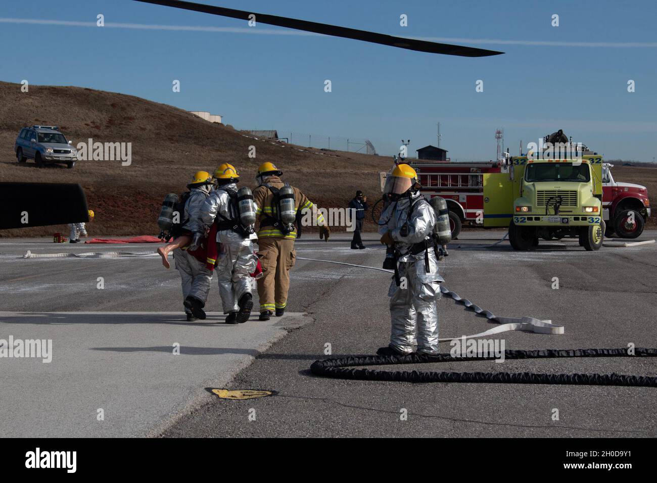 Members of the Camp Bondsteel Fire Department carry a simulated casualty to safety during a pre-accident plan rehearsal at the Camp Bondsteel air refueling point Jan. 29, 2021. Aviation personnel, military police, refuelers and the CBFD responded to a simulated aircraft emergency involving a UH-60 Blackhawk. After a fuel line broke and started the aircraft on fire, the CBFD safely extinguished the fire, allowing them to extract the simulated casualties from the aircraft. Stock Photo