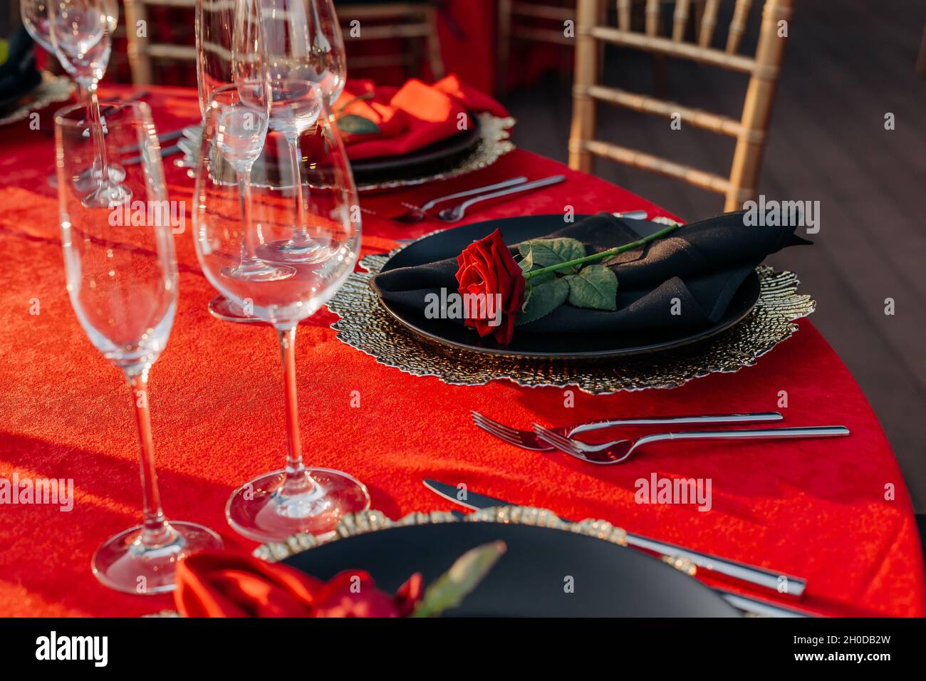 Guests table setting for banquet in black, red and gold style. Elegant