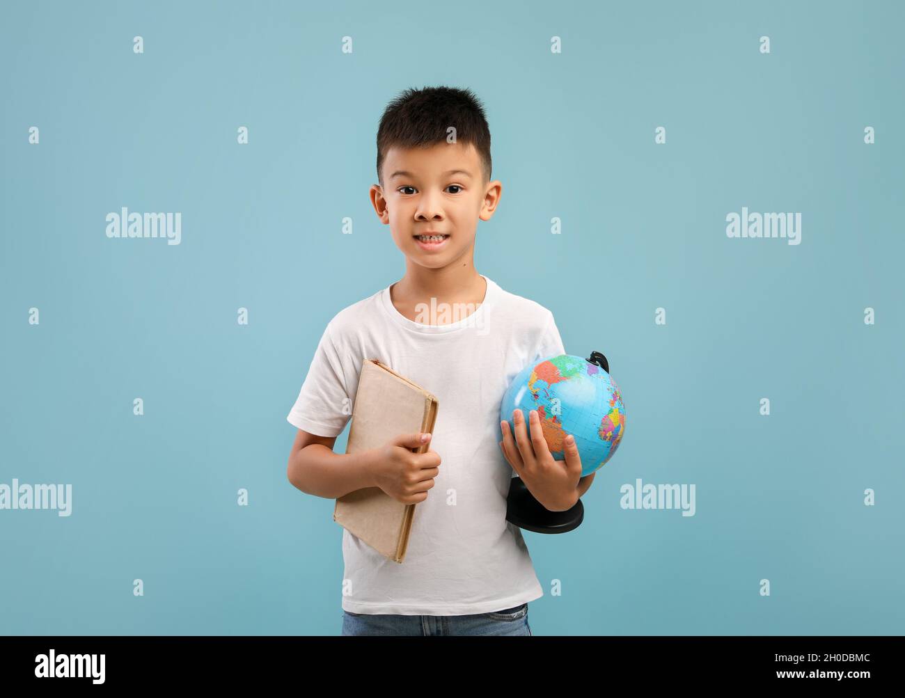 Portrait Of Little Asian Boy Holding Book And World Globe Stock Photo ...