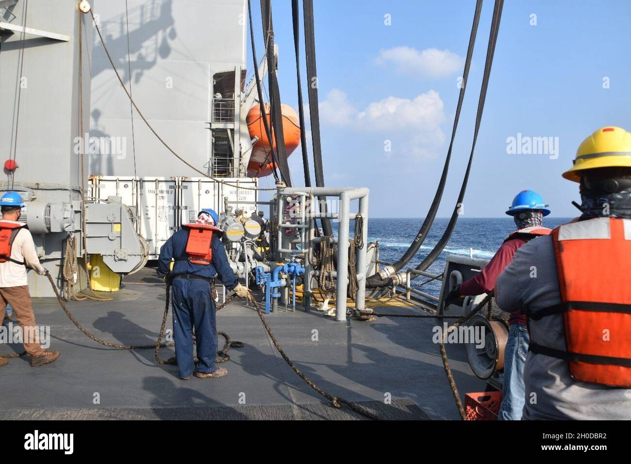 Civil service mariners aboard USNS Yukon (T-AO 202) prepare for an underway replenishment with USS Sterett (DDG 104).  Yukon is part of the U.S. Navy's Combat Logistics Force.  The fleet replenishment oiler provides fuel, cargo, and food to U.S. Navy and international partners' ships operating in the  Indo-Pacific Region. Stock Photo