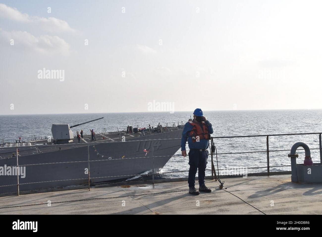 Herbert Russell, a civil service mariner aboard USNS Yukon (T-AO 202), prepares for an underway replenishment with USS Sterett (DDG 104).  Yukon is part of the U.S. Navy's Combat Logistics Force.  The fleet replenishment oiler provides fuel, cargo, and food to U.S. Navy and international partners' ships operating in the Indo-Pacific Region. Stock Photo