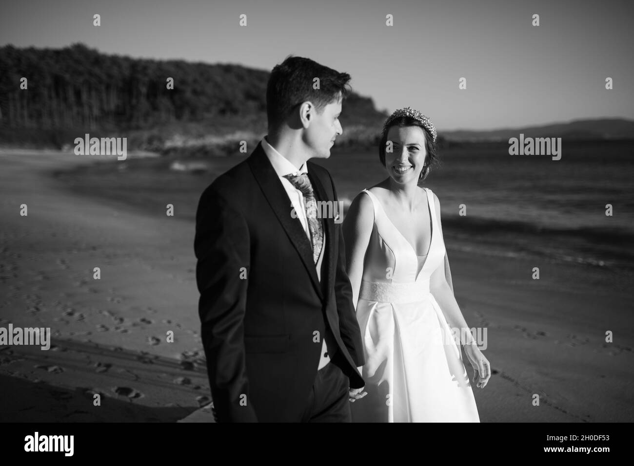 Just married couple walking on a beach on black and white Stock Photo ...